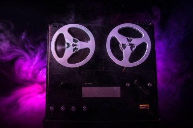 Koyu tonda sisli arka plan üzerinde makara oynatıcı ve kaydedici eski vintage makara. Analog Stereo Açık Makara Bant Güverte Kaydedici Çalar Makaralar ile. Seçici odaklama