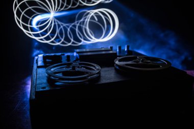 Koyu tonda sisli arka plan üzerinde makara oynatıcı ve kaydedici eski vintage makara. Analog Stereo Açık Makara Bant Güverte Kaydedici Çalar Makaralar ile. Seçici odaklama