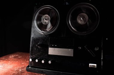 Koyu tonda sisli arka plan üzerinde makara oynatıcı ve kaydedici eski vintage makara. Analog Stereo Açık Makara Bant Güverte Kaydedici Çalar Makaralar ile. Seçici odaklama