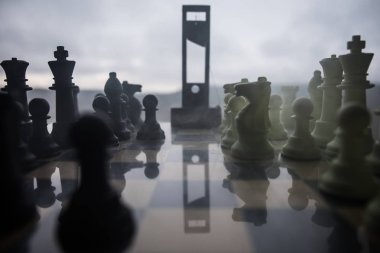 Chess board game concept of business ideas and competition and strategy ideas. Chess figures and Guillotine on a chessboard. Outdoor misty dark background. Selective focus clipart