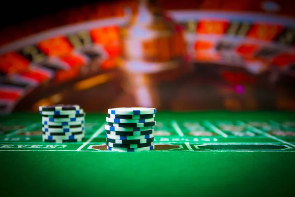 Cards and chips on green felt casino table. Abstract background with copy space. Gambling, poker, casino and cards games theme. Casino elements on green. Selective focus