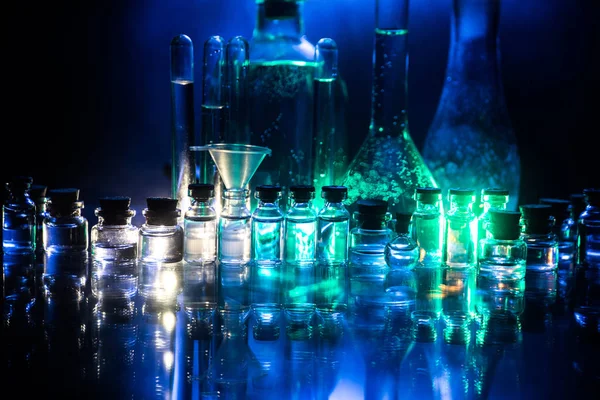 Pharmacy and chemistry theme. Test glass flask with solution in research laboratory. Science and medical background. Laboratory test tubes on dark toned background , science research equipment concept