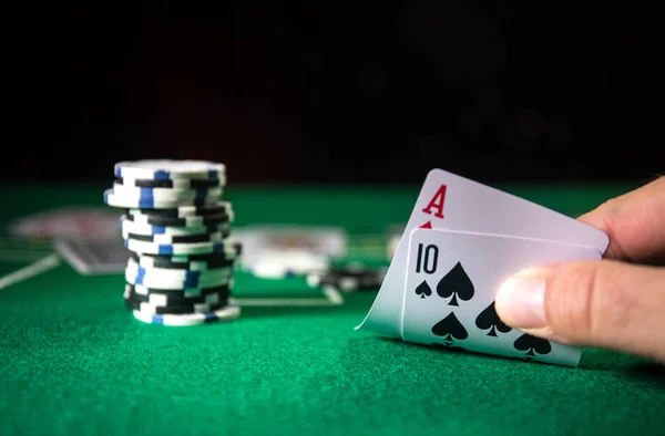 Cards and chips on green felt casino table. Abstract background with copy space. Gambling, poker, casino and cards games theme. Casino elements on green. Selective focus