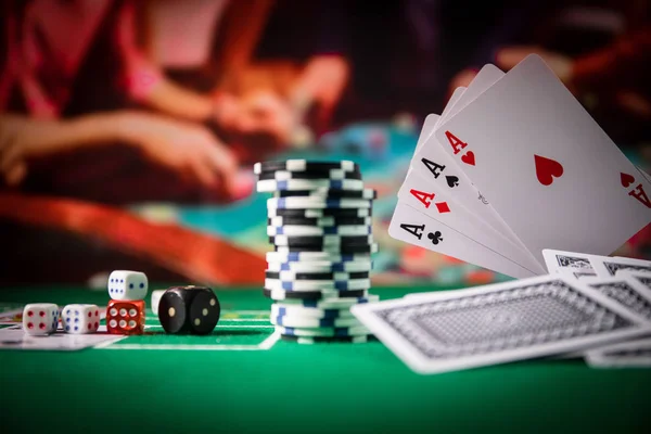 Cards and chips on green felt casino table. Abstract background with copy space. Gambling, poker, casino and cards games theme. Casino elements on green. Selective focus