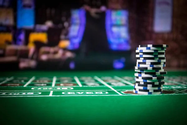 Cards and chips on green felt casino table. Abstract background with copy space. Gambling, poker, casino and cards games theme. Casino elements on green. Selective focus