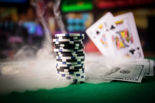 Cards and chips on green felt casino table. Abstract background with copy space. Gambling, poker, casino and cards games theme. Casino elements on green. Selective focus