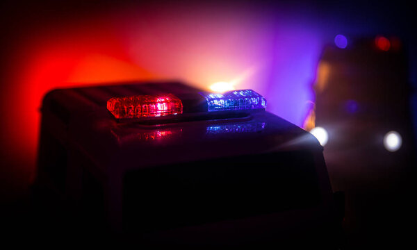 Police cars at night. Police car chasing a car at night with fog background. 911 Emergency response police car speeding to scene of crime. Selective focus