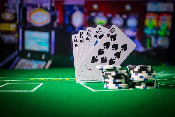 Cards and chips on green felt casino table. Abstract background with copy space. Gambling, poker, casino and cards games theme. Casino elements on green. Selective focus