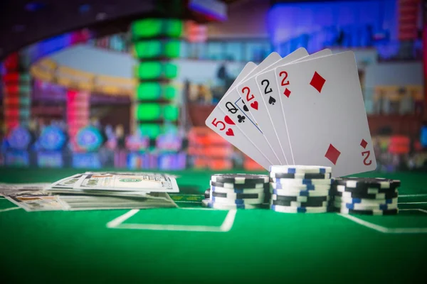 Cards and chips on green felt casino table. Abstract background with copy space. Gambling, poker, casino and cards games theme. Casino elements on green. Selective focus