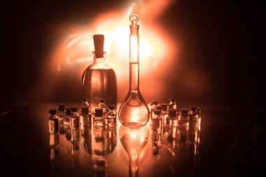 Eczane ve kimya teması. Araştırma laboratuarında çözeltisi olan cam deney şişesi. Bilim ve tıbbi geçmiş. Koyu renk arkaplan üzerinde laboratuvar test tüpleri, bilimsel araştırma ekipmanları konsepti