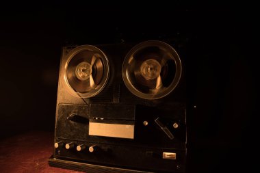 Koyu tonda sisli arka plan üzerinde makara oynatıcı ve kaydedici eski vintage makara. Analog Stereo Açık Makara Bant Güverte Kaydedici Çalar Makaralar ile. Seçici odaklama