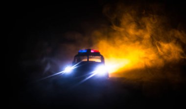 Geceleri polis arabaları. Polis arabası sisli bir arabayı gece takip ediyor. 911 acil durum arabası suç mahalline doğru hızla gidiyor. Seçici odak