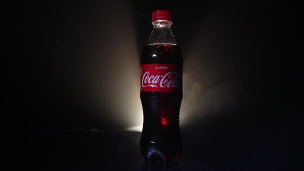 Baku, Azerbaijan 13 Januari 2018, Coca-Cola Classic dalam botol kaca di latar belakang berkabut gelap. Coca Cola adalah minuman ringan berkarbonasi paling populer yang dijual di seluruh dunia — Stok Video