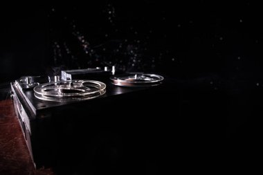 Koyu tonda sisli arka plan üzerinde makara oynatıcı ve kaydedici eski vintage makara. Analog Stereo Açık Makara Bant Güverte Kaydedici Çalar Makaralar ile. Seçici odaklama