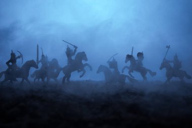 Süvari ve piyade ile ortaçağ savaş sahnesi. Siluetleri şekiller ayrı nesneler olarak mücadele günbatımı sisli arka plan savaşçılar arasında. Seçici odak