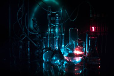 Eczacılık ve kimya teması. Araştırma laboratuvarında solüsyon lu cam şişesi test edin. Bilim ve tıbbi geçmiş. Koyu tonlu arka plan üzerinde laboratuvar test tüpleri