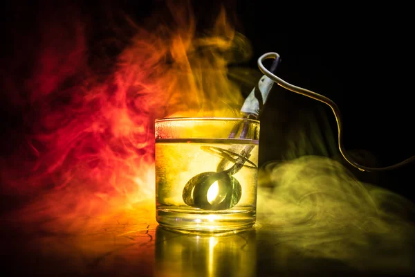 Vintage electric heater for brewing tea in a cup on dark toned foggy background. Heating water in a glass after mustard. The old method of brewing tea.