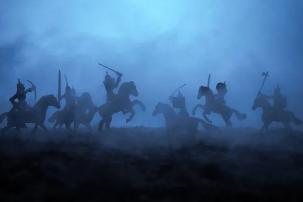 Medeltida strid scen med kavalleri och infanteri. Siluetter av siffror som separata objekt, kampen mellan krigare på sunset dimmig bakgrund. Selektivt fokus — Stockfoto