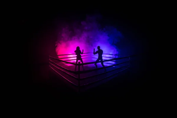 Man and woman boxing on the ring. Sport concept. Artwork decoration with foggy toned dark background.