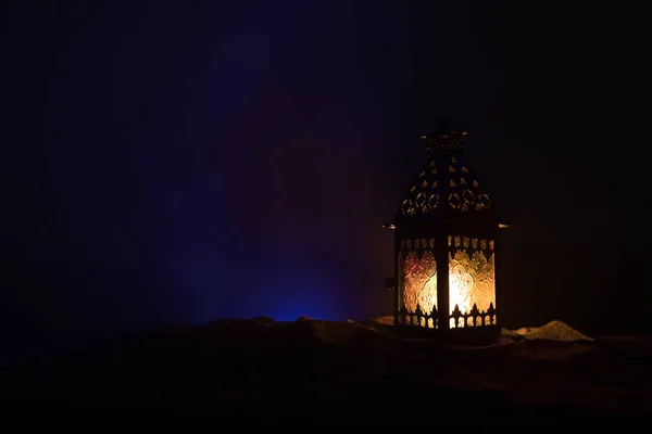 Versierde Arabische lantaarn met brandende kaars die 's nachts gloeit. Feestelijke wenskaart, uitnodiging voor islamitische heilige maand Ramadan Kareem. — Stockfoto