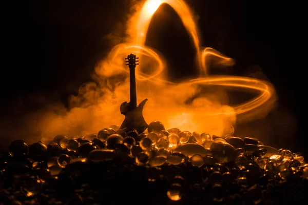 Concepto musical. Guitarra acústica aislada sobre un fondo oscuro bajo haz de luz con humo con espacio de copia. Cuerdas de Guitarra, de cerca. Enfoque selectivo. Efectos de fuego. Guitarra surrealista —  Fotos de Stock