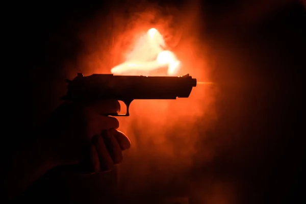 Mão Masculina Segurando Arma Fundo Preto Com Fumaça Tonificada Luzes — Fotografia de Stock