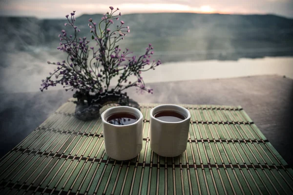 茶的概念 日本茶道文化东饮 茶壶和杯子在桌子上与竹子在日落 — 图库照片