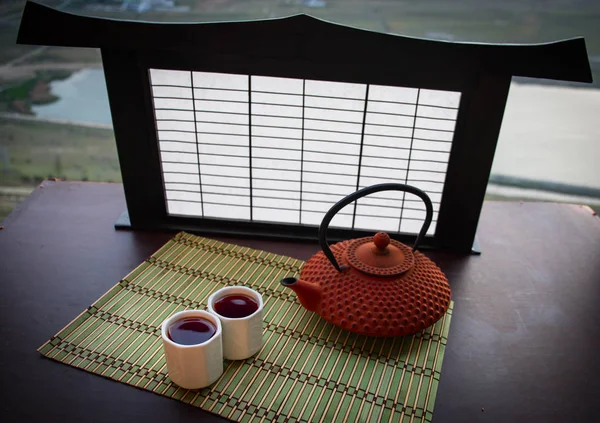 Tea concept. Japanese tea ceremony culture east beverage. Teapot and cups on table with bamboo on sunset