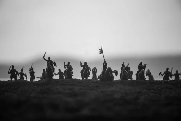 Cena de batalha medieval com cavalaria e infantaria. Silhuetas de figuras como objetos separados, luta entre guerreiros no pôr do sol fundo nebuloso . — Fotografia de Stock