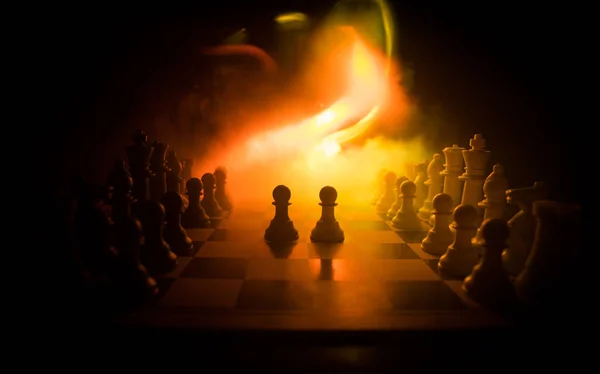 Schaakbord spel concept van Business ideeën en competitie. Schaak figuren op een donkere achtergrond met rook en mist. — Stockfoto