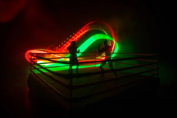 Man and woman boxing on the ring. Sport concept. Artwork decoration with toys on foggy toned dark background.