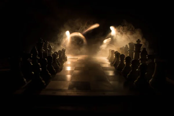 Chess board game concept of business ideas and competition. Chess figures on a dark background with smoke and fog. — Stock Photo, Image