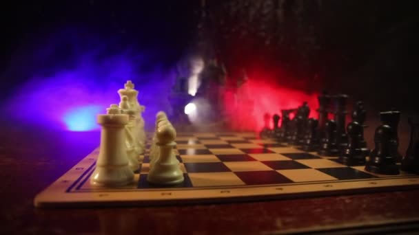 Tablero de ajedrez concepto de juego de ideas de negocios y la competencia y las ideas de estrategia cóncep. Figuras de ajedrez sobre un fondo oscuro con humo y niebla . — Vídeos de Stock