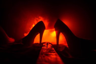 Resim dekorasyon. Sisli bir gecede dev yüksek topuklu Bayan Ayakkabı ile yolun ortasında duran bir adam silüeti. Kadın milleti yeti ya da kadın hakimiyeti kavramı. Seçici odak