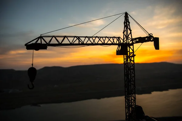 Resumo Fundo industrial com silhueta de guindaste de construção sobre incrível céu pôr do sol. Torre guindaste contra o céu da noite. Linha do horizonte industrial — Fotografia de Stock