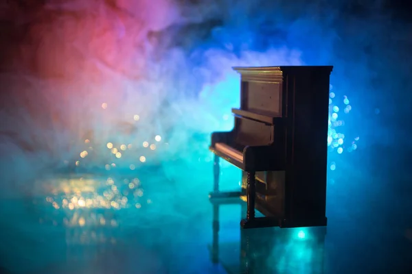 Kreatives Konzept. Kunstwerk Dekoration mit Klavier auf dunkel getöntem nebligem Hintergrund mit Licht. — Stockfoto