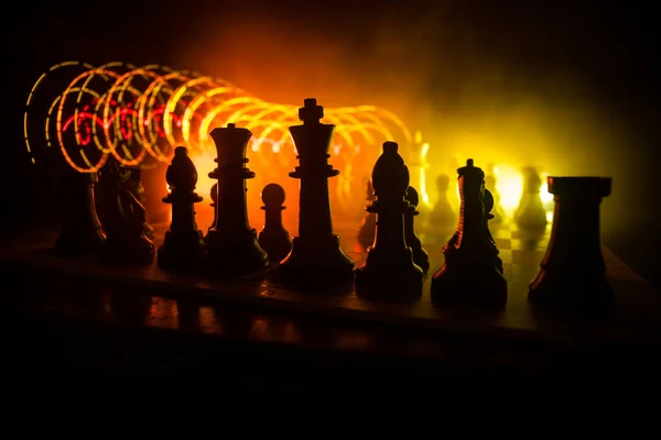 Juego de mesa de ajedrez concepto de ideas de negocio y competencia. Figuras de ajedrez sobre un fondo oscuro con humo y niebla . —  Fotos de Stock