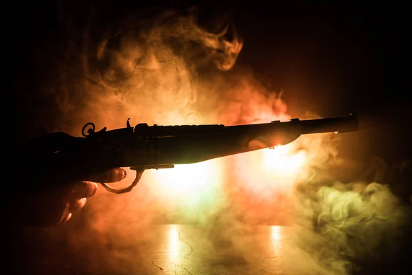Pistola de mano masculina sobre fondo negro con luces traseras tonificadas con humo. Silueta de un arma en la mano. Concepto de crimen . — Foto de Stock