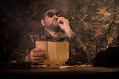 Masada oturan kötü diktatör. Kızgın komünist general karargâhta oturuyor ya da Küba lı komutan karanlık odada.