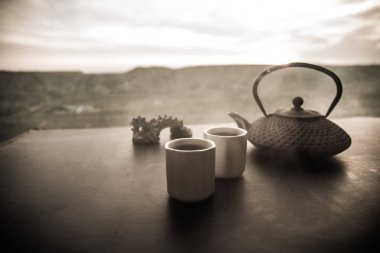 Çay konsepti. Japon çay töreni kültür doğu içecek. Gün batımında bambu yaprakları ile masada çaydanlık ve bardak
