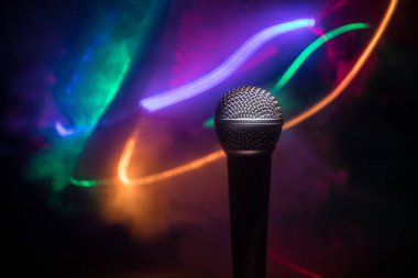 Mikrofon karaoke, konser. Bulanık arka plan ile düşük ışıkta ses mikrofonu. Canlı müzik, ses ekipmanları. Karaoke konseri, şarkı sesi. Karaokelerde şarkıcı, mikrofon.