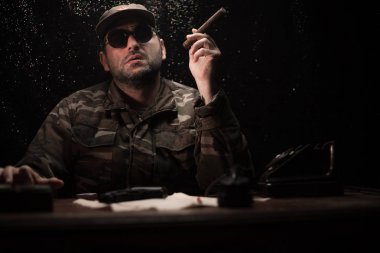 Masada oturan kötü diktatör. Kızgın komünist general karargâhta oturuyor ya da Küba lı komutan karanlık odada.