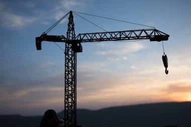Şaşırtıcı günbatımı gökyüzü üzerinde inşaat vinç silueti ile Soyut Endüstriyel arka plan. Akşam gökyüzüne karşı kule vinç. Endüstriyel ufuk çizgisi