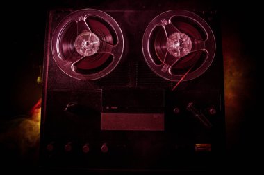 Koyu tonda sisli arka plan üzerinde makara oynatıcı ve kaydedici eski vintage makara. Makaralı Analog Stereo Açık Makara Bant Güverte Kaydedici Çalar.