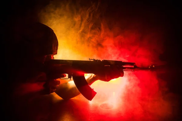 Silhouette des Mannes mit Sturmgewehr bereit zum Angriff auf dunkel getönten nebligen Hintergrund oder gefährlichen Banditen mit Waffe in der Hand. — Stockfoto
