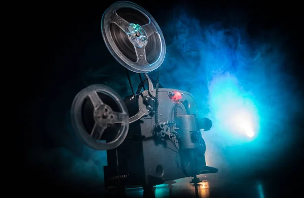 Oude vintage film projector op een donkere achtergrond met mist en licht. Concept van het maken van films. — Stockfoto