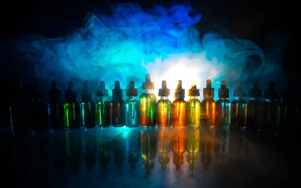Vape 개념입니다. 어두운 배경에 연기 구름과 vape 액체 병. 라이트 효과. 배경 또는 전자 담배 광고로 유용. — 스톡 사진