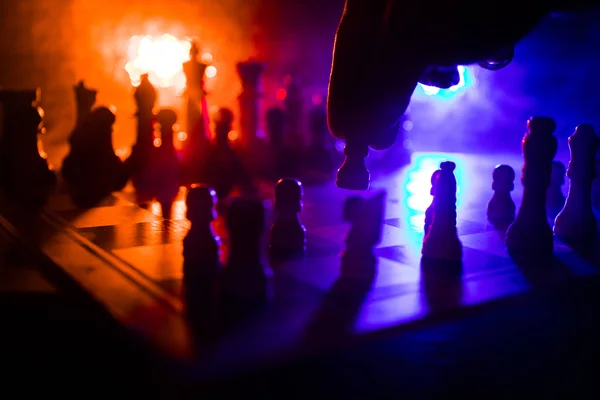 Juego de mesa de ajedrez concepto de ideas de negocio y competencia. Figuras de ajedrez sobre un fondo oscuro con humo y niebla . —  Fotos de Stock