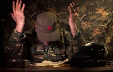 Masada oturan kötü diktatör. Kızgın komünist general karargâhta oturuyor ya da Küba lı komutan karanlık odada.