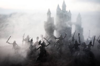 Süvari ve piyade ile Ortaçağ savaş sahnesi. Ayrı nesneler olarak figürlerin siluetleri, gün batımı sisli arka plan üzerinde savaşçılar arasında mücadele.